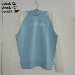 A light blue and white color block pullover hoodie by Kappa, featuring a large white logo and raglan sleeves, photographed on a hanger.