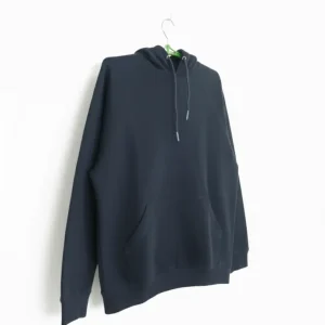A plain black pullover hoodie with a drawstring hood and a large front kangaroo pocket, photographed on a hanger.