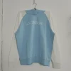 A light blue and white color block pullover hoodie by Kappa, featuring a large white logo and raglan sleeves, photographed on a hanger.