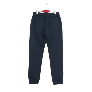 Back view of dark navy blue tapered joggers/chinos showing the cuffed ankles and sleek back welt pockets.