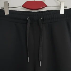 Front view of black joggers/sweatpants showing the adjustable drawstring waist and side pockets.